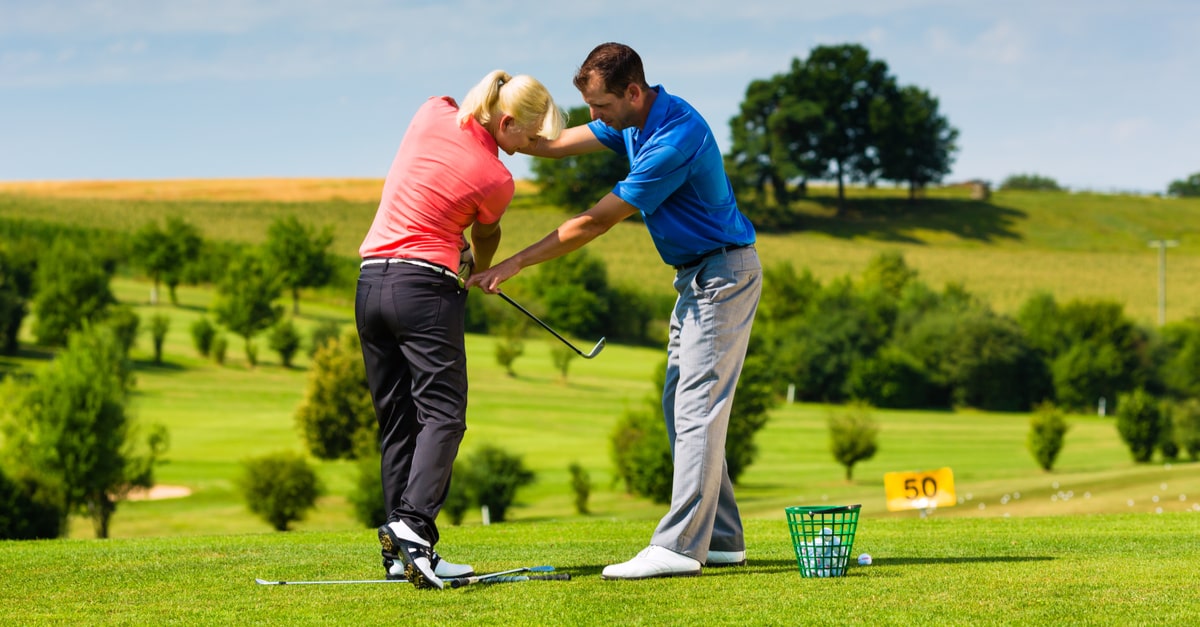Eine Frau trainiert mit einem Golftrainer
